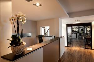 a living room with a counter with a vase with flowers at Hotel Seeluna am Klostersee in Ebersberg