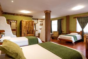 1 Schlafzimmer mit 2 Betten in Grün und Weiß in der Unterkunft EL DESCANSO DEL TORO HOSTERIA-SPA in Vilcabamba