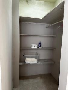 a walk in closet with white shelves and towels at The Shelton - Sinclair in Montego Bay