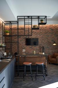 a kitchen with two bar stools and a tv on a brick wall at Plebiscito Old Fashion in Castel di Sangro