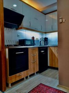 a kitchen with wooden cabinets and a black dishwasher at Me Van, outstanding, modern and stylish in the city centre in Van