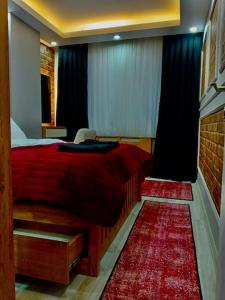 a bedroom with a red bed and a red rug at Me Van, outstanding, modern and stylish in the city centre in Van