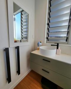 a bathroom with a sink and a mirror at Artist Photographers Home Studio in Auckland