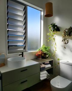a bathroom with a sink and a window at Artist Photographers Home Studio in Auckland