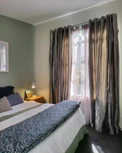 a bedroom with a bed and a window with curtains at Artist Photographers Home Studio in Auckland