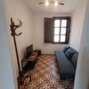 een woonkamer met een blauwe bank en een bureau bij HOTEL BODEGA VERA DE ESTENAS in Utiel