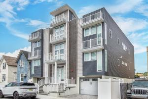 a large house with cars parked in front of it at Modern Condo-NYC@Fingertips in North Bergen