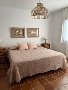 een slaapkamer met een groot bed en een kroonluchter bij Comodo apartamento en Bahia de la Plata in Zahara de los Atunes