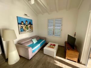 a small bedroom with a bed and a television at Au coin des baigneuses in Saint-François