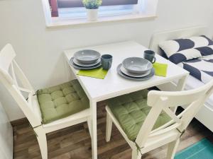 凱撒斯勞滕的住宿－Nette Unterkunft, günstige Lage，白色的桌椅,上面有盘子和盘子