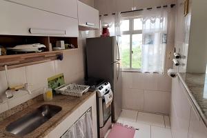 a small kitchen with a sink and a stove at Cobertura Pôr do Sol Saquarema in Saquarema