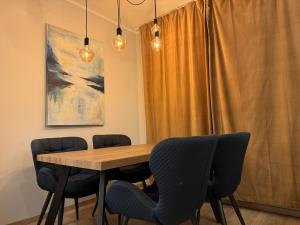 een eetkamer met een houten tafel en stoelen bij Modern 4-Room compact flat with parking in Riga in Dreiliņi