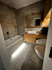 La salle de bains est pourvue d'un lavabo, d'une baignoire et de toilettes. dans l'établissement Apartament Luca, à Cracovie