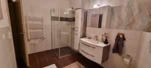 a white bathroom with a shower and a sink at Ferienwohnung Maasch in Vierraden +10 photos