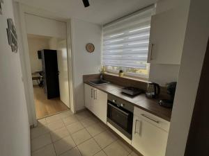a kitchen with white cabinets and a window with a sink at Penthouse Apartment in Kehl in Kehl am Rhein