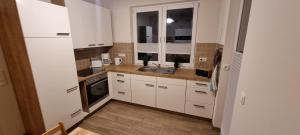 a small kitchen with white cabinets and a sink at Ferienwohnung Maasch in Vierraden
