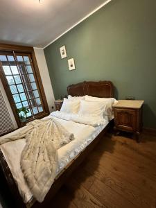 an unmade bed in a bedroom with a window at Apartament Luca in Krakow