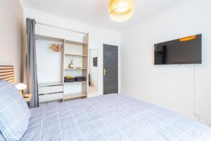 1 dormitorio con 1 cama y TV de pantalla plana en Nid douillet entre Paris et Disney, en Vaires-sur-Marne