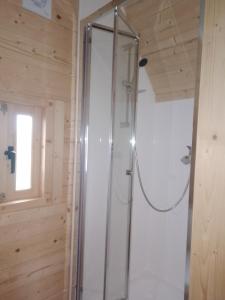 uma cabina de duche em vidro numa casa de banho com uma janela em La Halte du Canal em Luthenay-Uxeloup