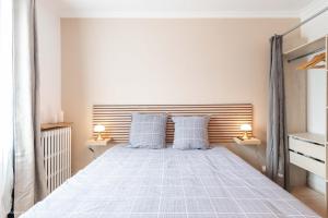 ein Schlafzimmer mit einem Bett mit zwei blauen Kissen in der Unterkunft Nid douillet entre Paris et Disney in Vaires-sur-Marne