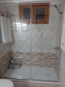 y baño con ducha y puerta de cristal. en Casa Los Jameos en Punta de Mujeres