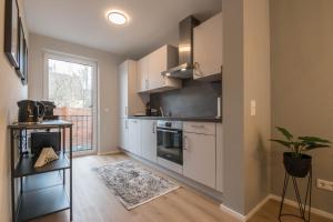 a kitchen with white cabinets and a stove at Wiesbaden Business Appartement in Wiesbaden