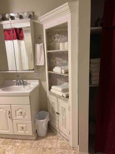 a bathroom with a sink and a cabinet with towels at Cozy, Pet-friendly Ligonier in Ligonier