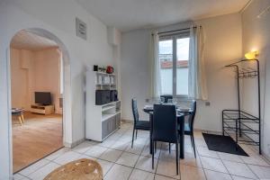 a dining room with a table and chairs in a room at Le Guynemer - Rocade / Tram in Grenoble +12 photos