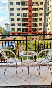un patio con 2 sillas y una mesa en el balcón en Executive two bedrooms, en Nairobi