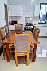 una mesa de madera y sillas en la cocina en Executive two bedrooms, en Nairobi