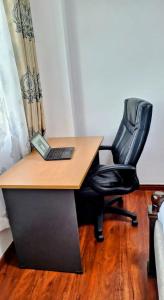 escritorio con silla y ordenador portátil en Executive two bedrooms, en Nairobi