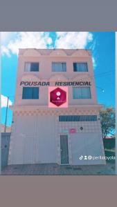 a pink building with a sign on it at Pousada residencial in Curvelo