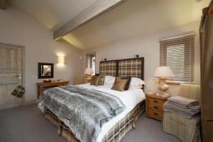 Ness Castle Lodges في إينفيرنيس: غرفة نوم بسرير كبير ومصباحين