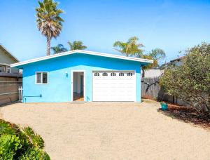 a blue house with a white garage at Oceano: Short walk to beach, 4 br, 2 bath, private house! Across street from park & pond in Oceano