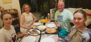un grupo de personas de pie alrededor de una mesa con comida en Suvaasa Inn, en Omadhoo