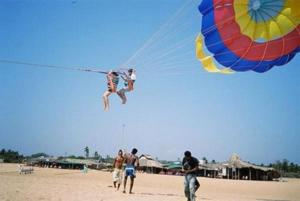 a person jumping into the air with a kite on the beach at Pool View Studio Apartment in Candolim Beach Resort in Baga