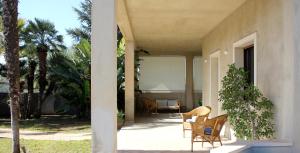 Villa Sam في كوميزو: شرفة منزل مع كراسي وطاولة