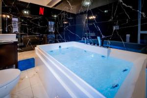 a bath tub with blue water in a bathroom at Exclusive with Jacuzzi between Portofino and 5 Terre in Chiavari