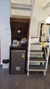 a small refrigerator and stairs in a tiny house at Pool View Studio Apartment in Candolim Beach Resort in Baga