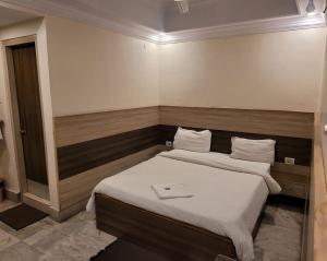 een slaapkamer met 2 bedden en witte lakens bij HOTEL MERIDIAN in Jamshedpur