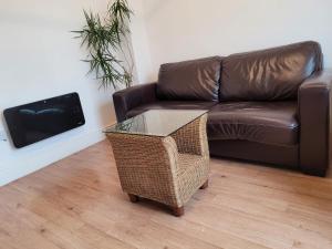 - un salon avec un canapé brun et une table en verre dans l'établissement Heart of City DE1 One Bedroom Apartment, à Derby