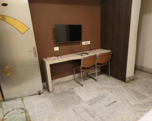 Zimmer mit einem Schreibtisch, einem Computer und einem TV. in der Unterkunft HOTEL MERIDIAN in Jamshedpur