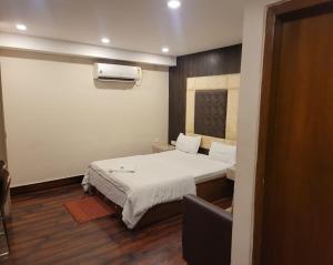 a small room with a bed and a television at HOTEL MERIDIAN in Jamshedpur