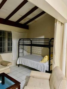 a bedroom with a bunk bed and a couch at Widcombe House in Kingston