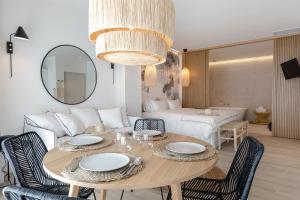 a dining room with a table with chairs and a couch at Les Suites de Collioure - Les Suites Collection in Collioure