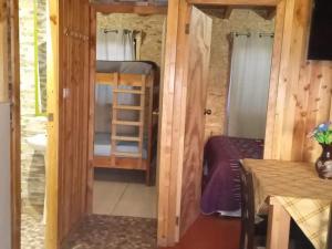 a small room with a bunk bed and a bathroom at cabaña villa la dehesa in Panguipulli