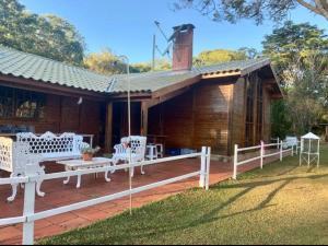 a wooden house with white chairs and a porch at Terrinha Nosso Paraíso in São Carlos
