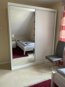 um espelho num quarto com uma cama e uma cadeira em Diner Nord 2 em Ostercappeln
