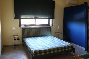 a bedroom with a bed with a blue wall and a window at Villa Sam in Comiso