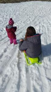 two children playing in the snow on a sled at Casas da Fraga - Serra da Estrela in Fornos de Algodres